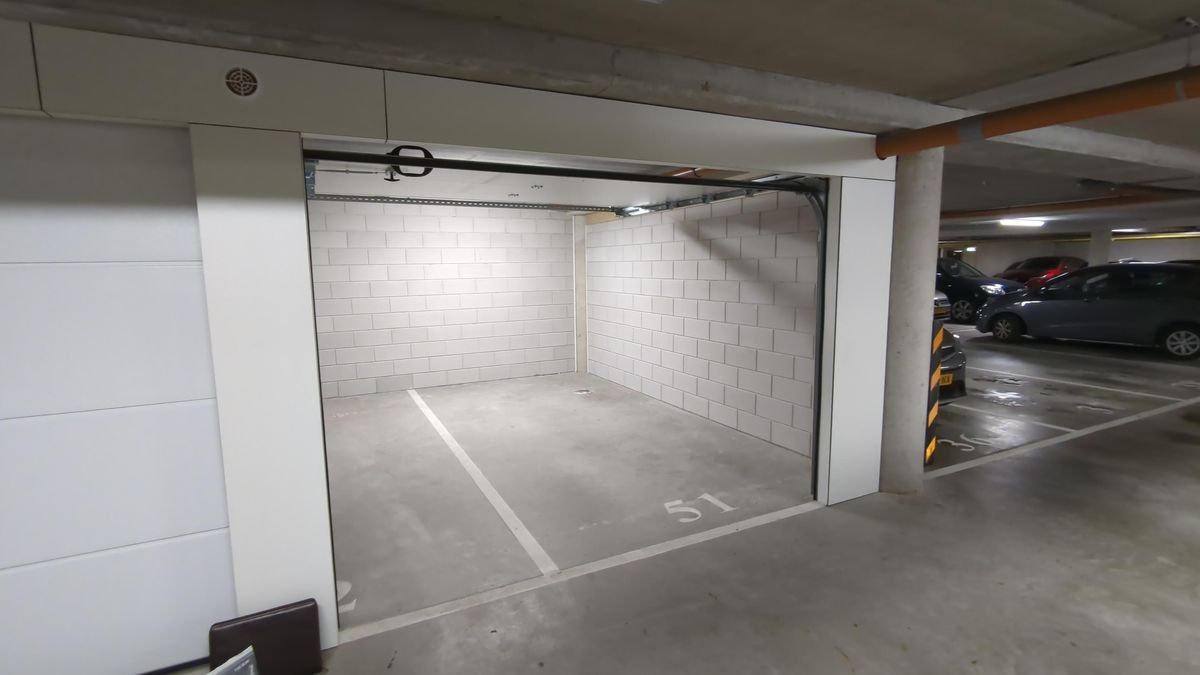 Open garagebox met zicht op parkeerkelder en geparkeerde auto's